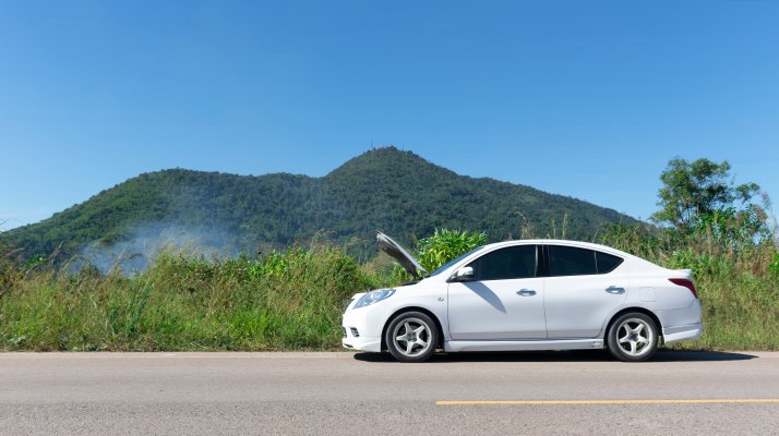 extended car warranty white car on the road with open hood mountains in the background